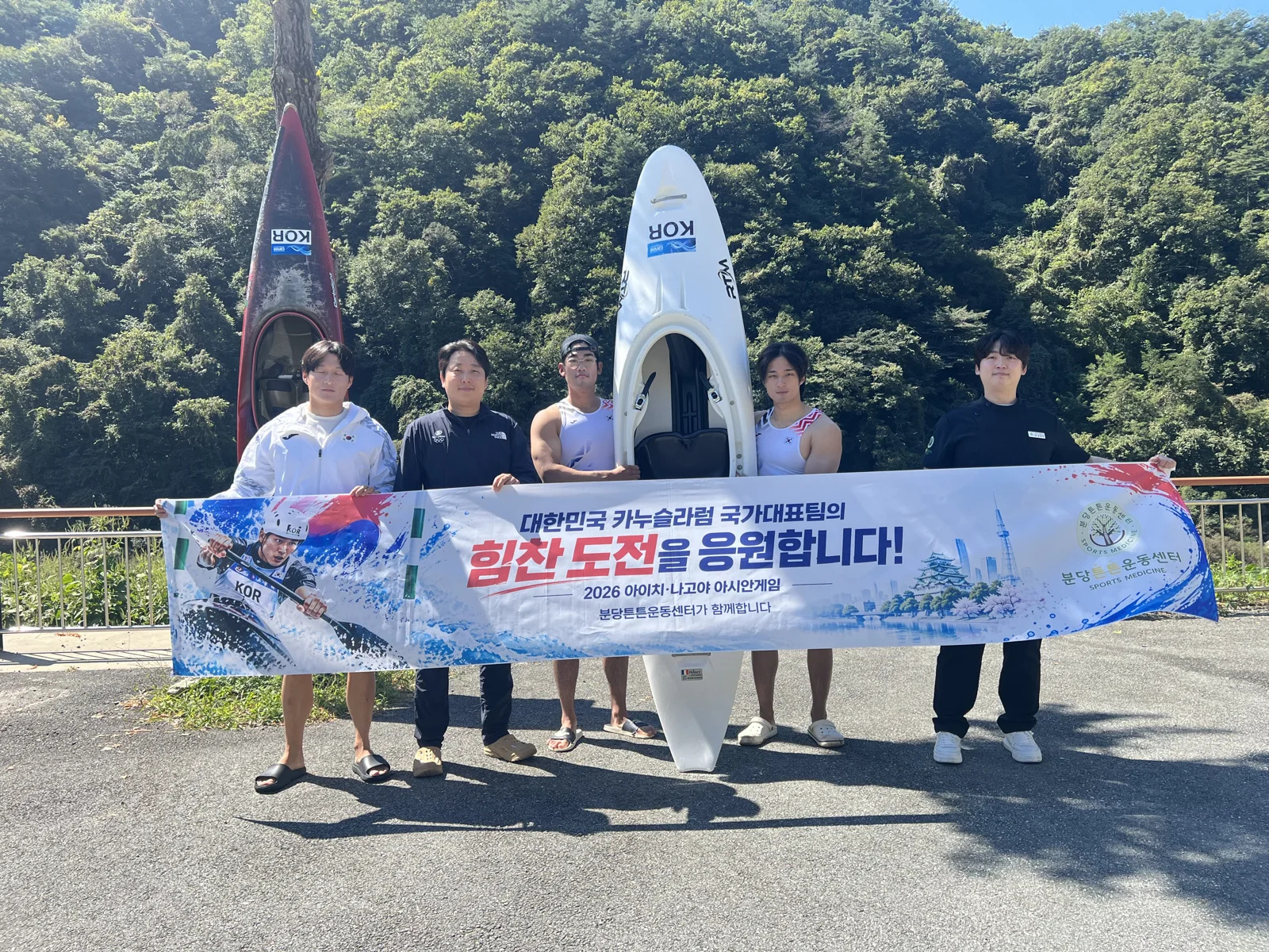 카누와 분당튼튼운동센터 응원 현수막을 배경으로 함께한 단체 기념사진